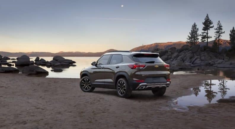 A brown and white 2021 Chevy Trailblazer ACTIV is parked in front of a lake at dusk.