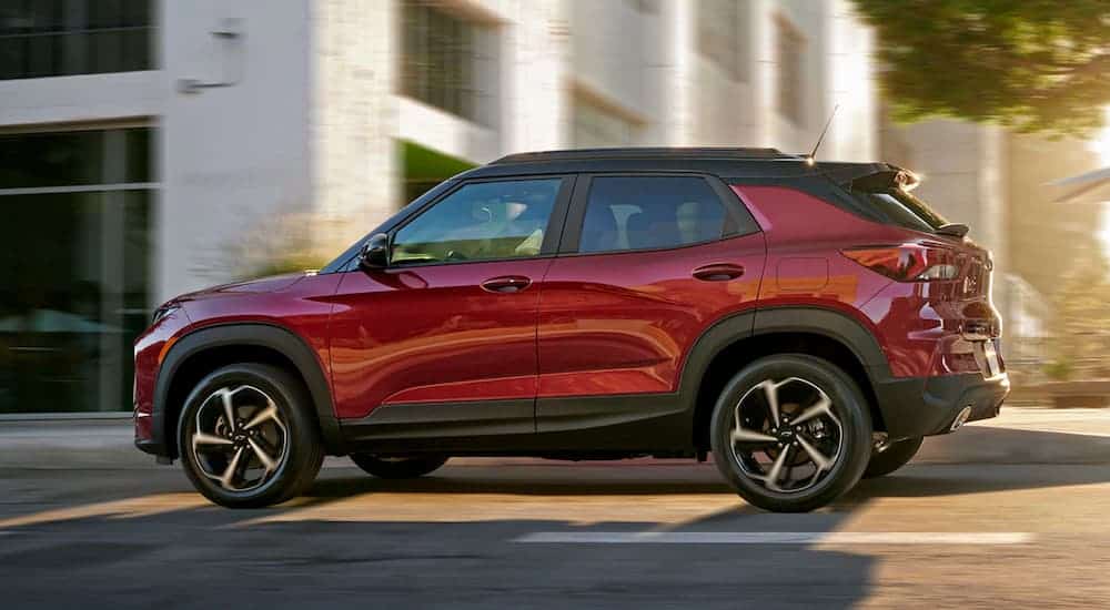 A red 2021 Chevy Trailblazer is driving down a city street.