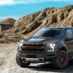 A grey 2020 Ford Raptor ROUSH Edition is parked in front of desert rocks.