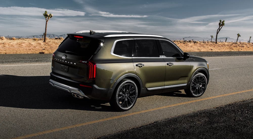 A green Telluride is driving away into the desert after losing the 2020 Cadillac XT6 vs 2020 Kia Telluride comparison.