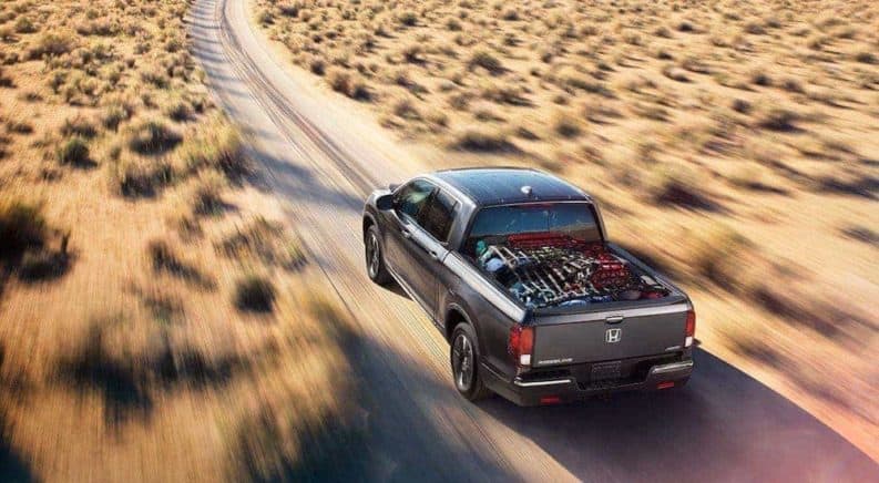 A gray 2020 Honda Ridgeline RTL-E is shown from above driving in the desert.