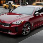A red 2020 Kia Stinger is parked on a city street.