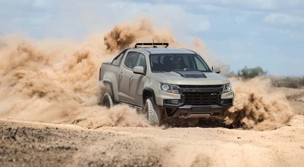 A tan 2021 Chevy Colorado ZR2 is kicking up sand in the desert after winning the 2021 Chevy Colorado vs 2020 Chevy Colorado comparison.