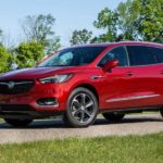 A red 2020 Buick Enclave is parked at a park with bikes on the liftgate.