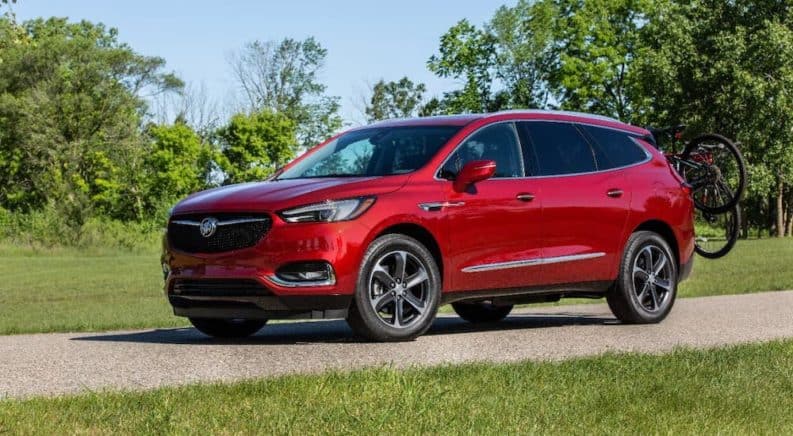 A red 2020 Buick Enclave is parked at a park with bikes on the liftgate.