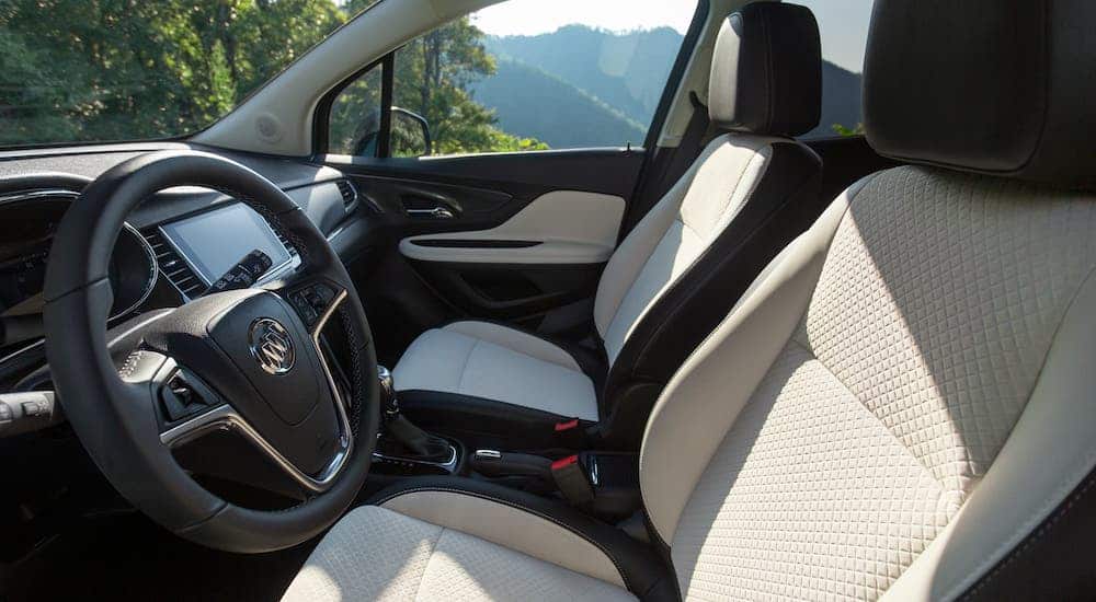 The interior front seats of a 2020 Buick Encore is shown with available white leather seats.