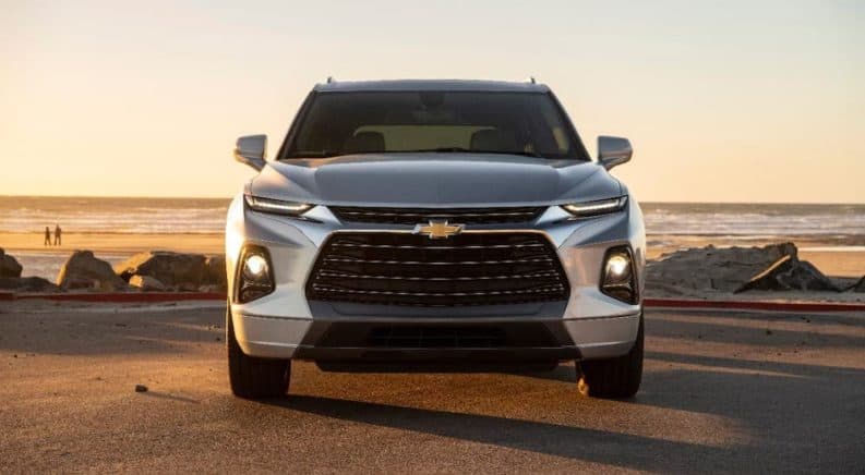 A silver 2020 Chevy Blazer is parked on a beach at sunset and shown from the front.