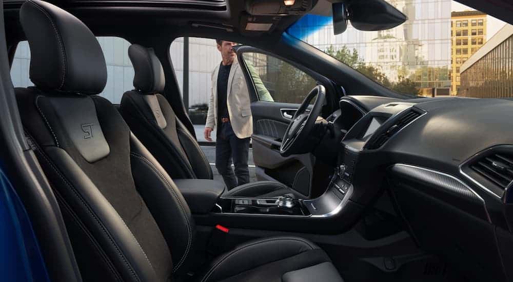 A man is opening the door to a 2020 Ford Edge ST, shown from the inside.