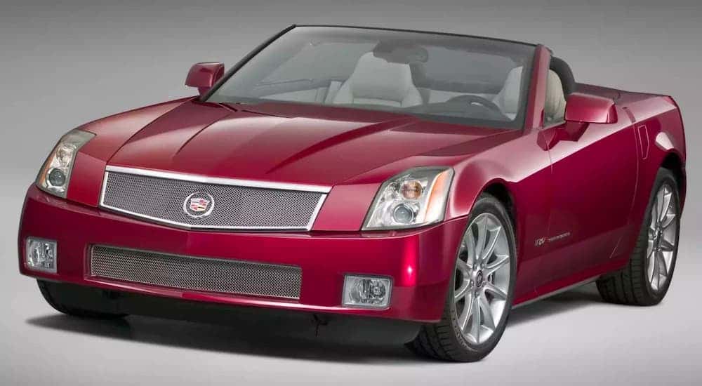 A red 2006 Cadillac XLR-V convertible is against a gray background.