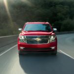 A red 2020 Chevy Tahoe, which wins when comparing the 2020 Chevy Tahoe vs 2020 Ford Expedition, is facing forward after taking a corner.
