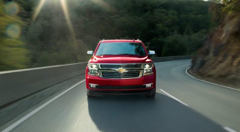 A red 2020 Chevy Tahoe, which wins when comparing the 2020 Chevy Tahoe vs 2020 Ford Expedition, is facing forward after taking a corner.