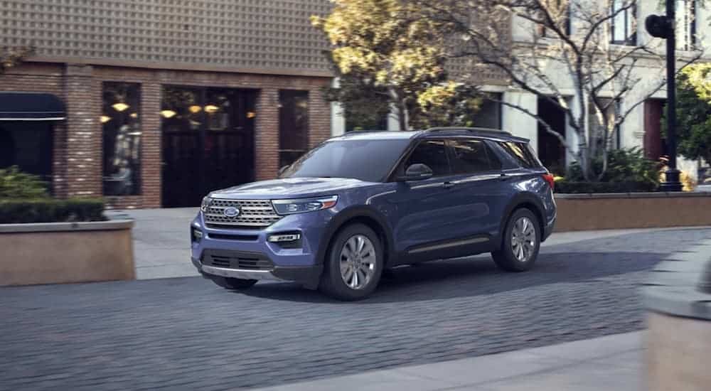 A blue 2020 Ford Explorer is parked on a city street.