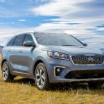 A grey 2020 Kia Sorento is parked in a field in front of mountains after winning the 2020 Kia Sorento vs 2020 Mazda CX-9 comparison.