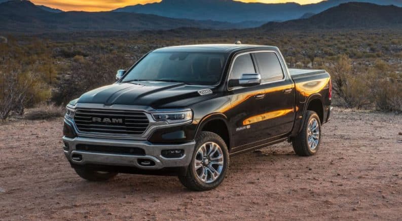 A black 2019 used Ram 1500 is parked in front of mountains at sunset.