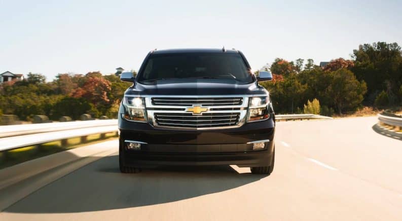 A black 2020 Chevy Suburban is shown driving on a mountain highway.