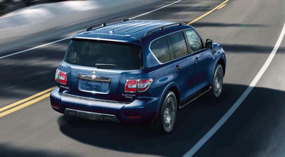 A blue 2020 Nissan Armada is driving away on a highway after losing the 2020 GMC Yukon vs 2020 Nissan Armada comparison.