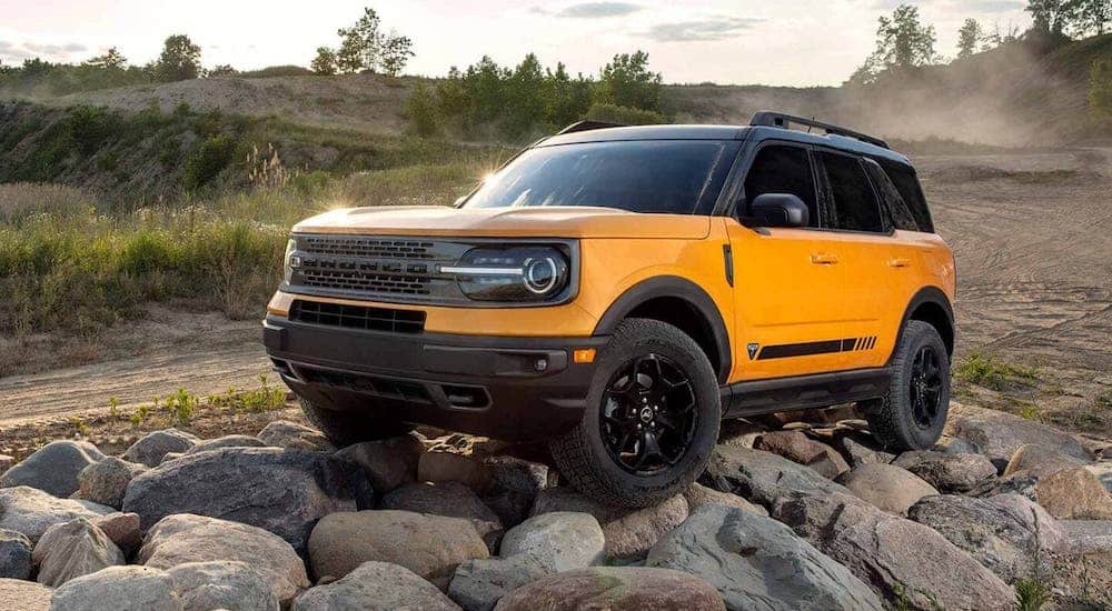 A yellow 2021 Ford Bronco Sport is parked on a pile of rocks.