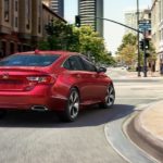 A red 2020 Honda Accord is driving around a city corner.