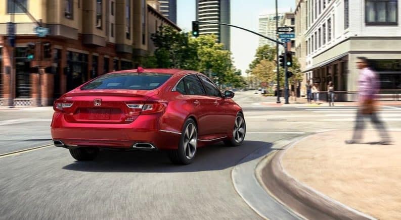 A red 2020 Honda Accord is driving around a city corner.
