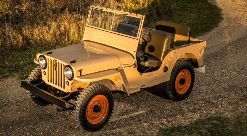 A 1940s Jeep CJ is shown from a high angle on a dirt road.