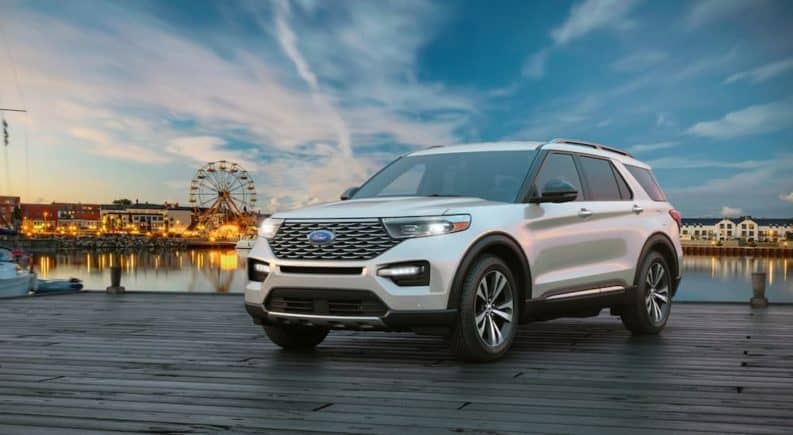 A white 2020 Ford Explorer is parked on a pier in front of a fair.