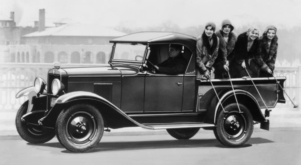 A black and white picture shows women in the bed of a 1930s Chevy Roadster Truck.