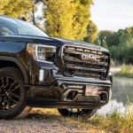 A closeup shows the grille on 2019 GMC Sierra Elevation parked in front of a pond.