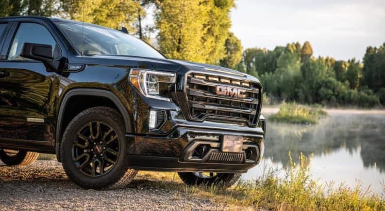 A closeup shows the grille on 2019 GMC Sierra Elevation parked in front of a pond.