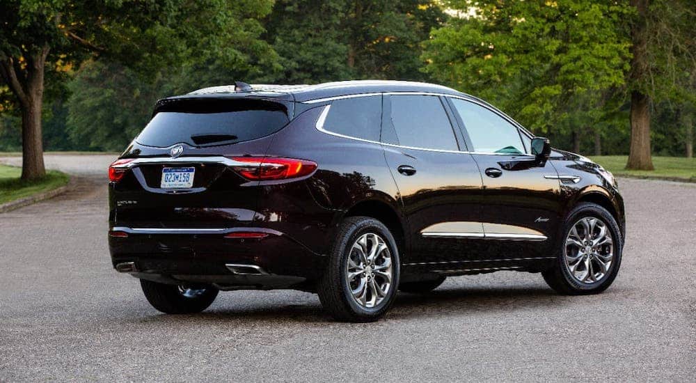 A black 2020 Buick Enclave is facing away and parked in a parking lot.