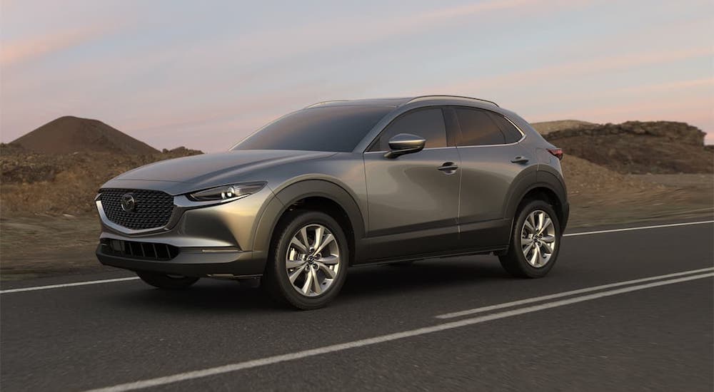 A gray 2020 Mazda CX-30 is driving on a desert highway.