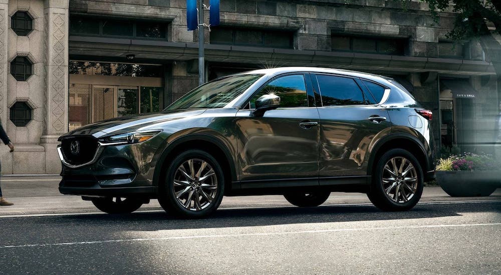 A gray 2020 Mazda CX-5 is parked on a city street after losing the 2020 Chevy Equinox vs 2020 Mazda CX-5 comparison.