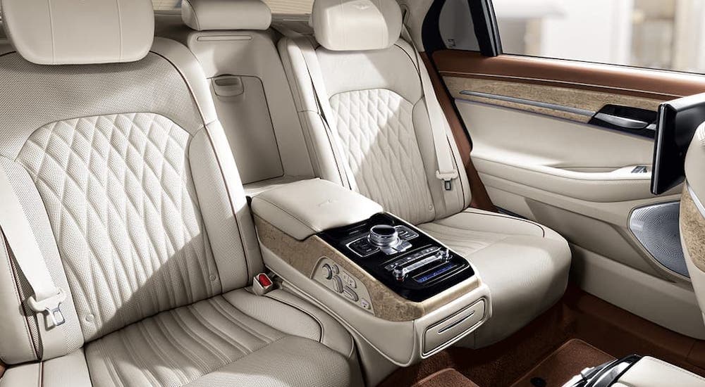 The luxurious cream-colored back seats of a 2020 Genesis G90 are shown.