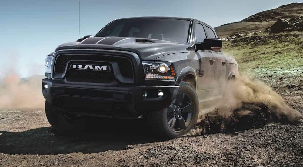 A black 2020 Ram 1500 Classic Warlock is off-roading in the dirt.
