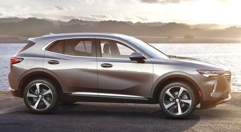A silver 2021 Buick Envision is shown from the side in front of a river.