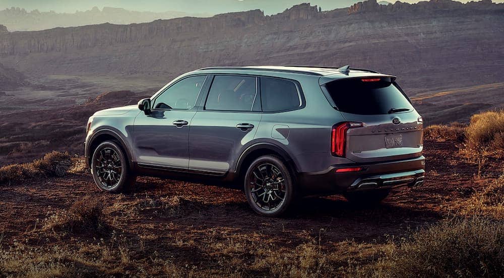 A silver 2021 Kia Telluride is parked in front of desert mountains.