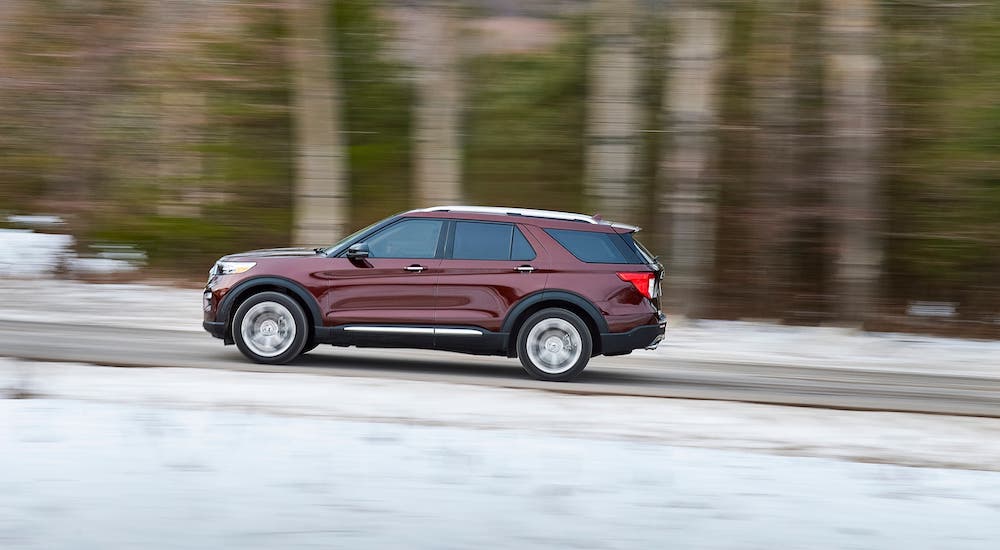 A burgundy 2020 Ford Explorer is driving on a snowy road after losing the 2021 Kia Telluride vs 2020 Ford Explorer comparison.
