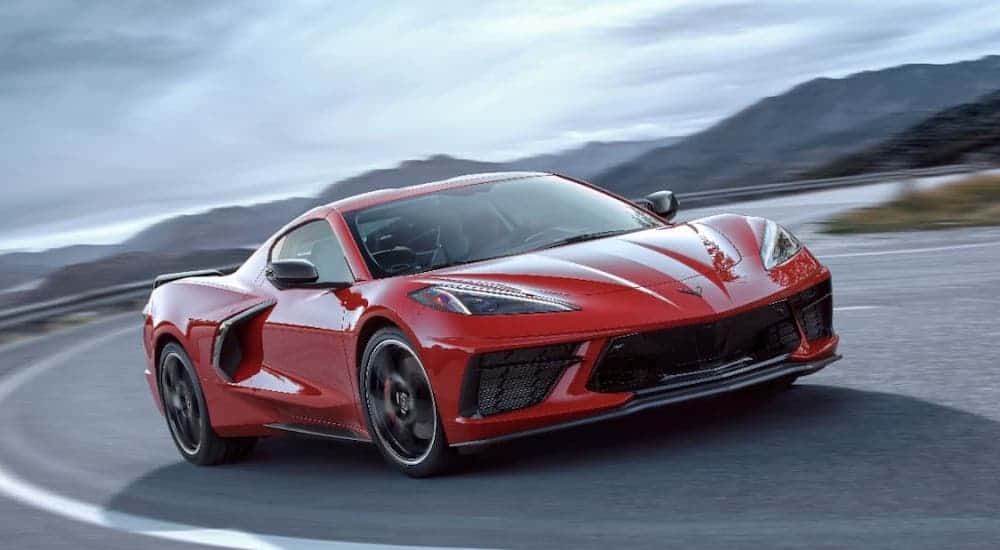 A red 2021 Chevy Corvette, soon to be at a Chevy dealer near you, is driving on an empty highway.