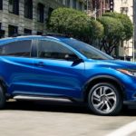 A blue 2020 Honda HR-V is driving through a city intersection in a comparison of the 2020 Honda HR-V vs 2020 Chevy Trax.