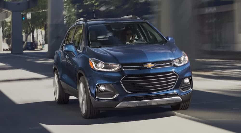 A blue 2020 Chevy Trax is driving down a city street.