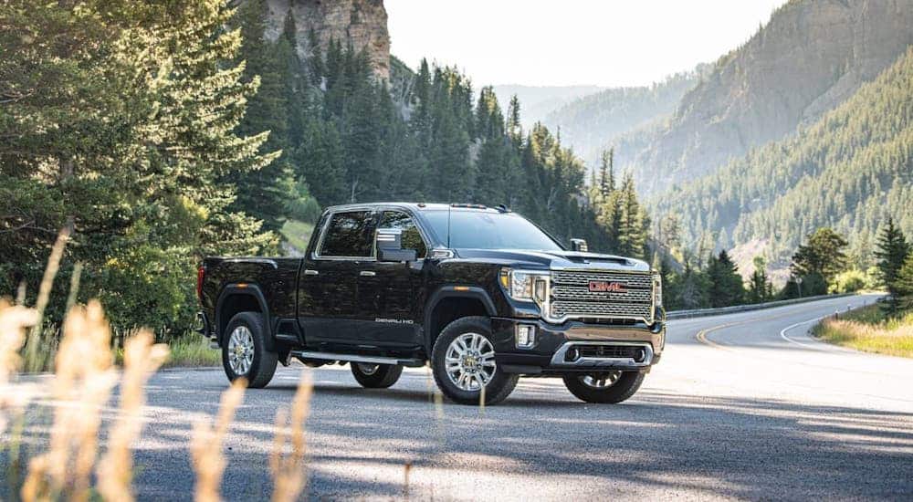 A black 2020 GMC Sierra 2500 Denali is parked on the side of a mountain road.