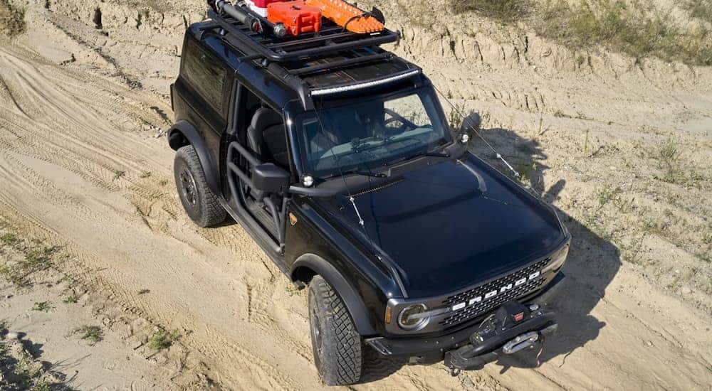 A black 2021 Ford Bronco 2dr is shown from above on sand with off-roading accessories after winning the 2021 Ford Bronco vs 2020 Jeep Wrangler comparison.