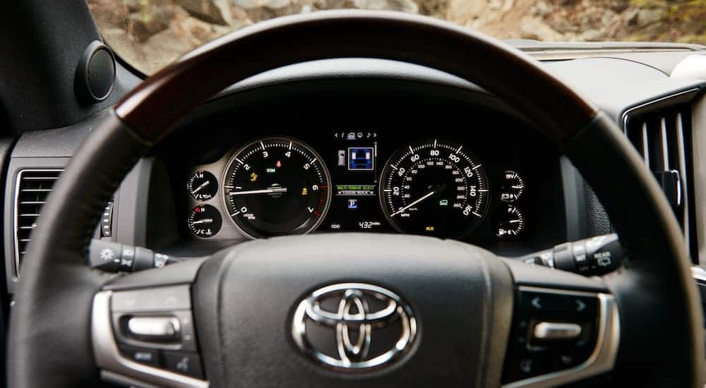 The dashboard features behind the steering wheel are shown in a 2021 Toyota Land Cruiser.