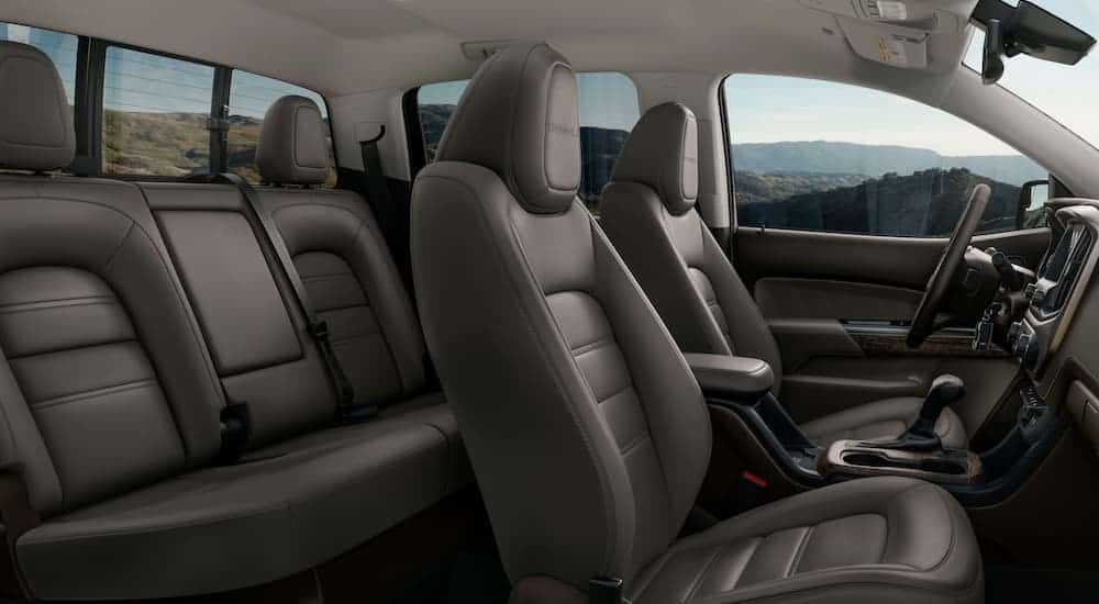 The grey and tan interior in a 2021 GMC Canyon Denali is shown from the side.