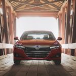A red 2021 Honda Accord, a popular Honda car, is in a wooden, covered bridge.