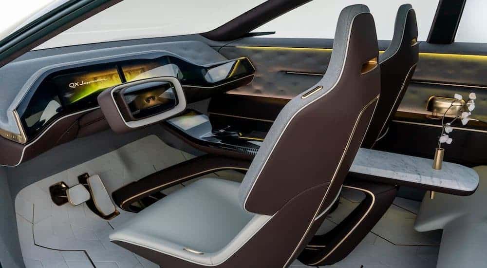 An interior view of the Infiniti QX Inspiration concept car is showing the futuristic looking front seats and dashboard.