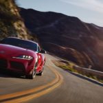 A red 2020 Toyota GR Supra from a local Toyota dealership is driving around a winding road.