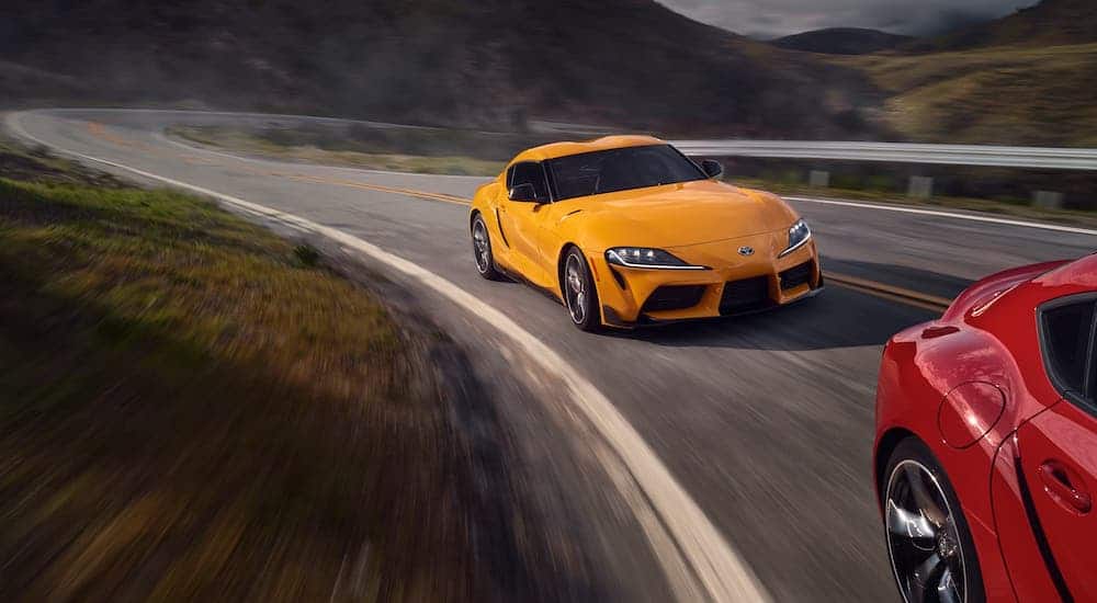 A yellow 2020 Toyota GR Supra is driving around a track.