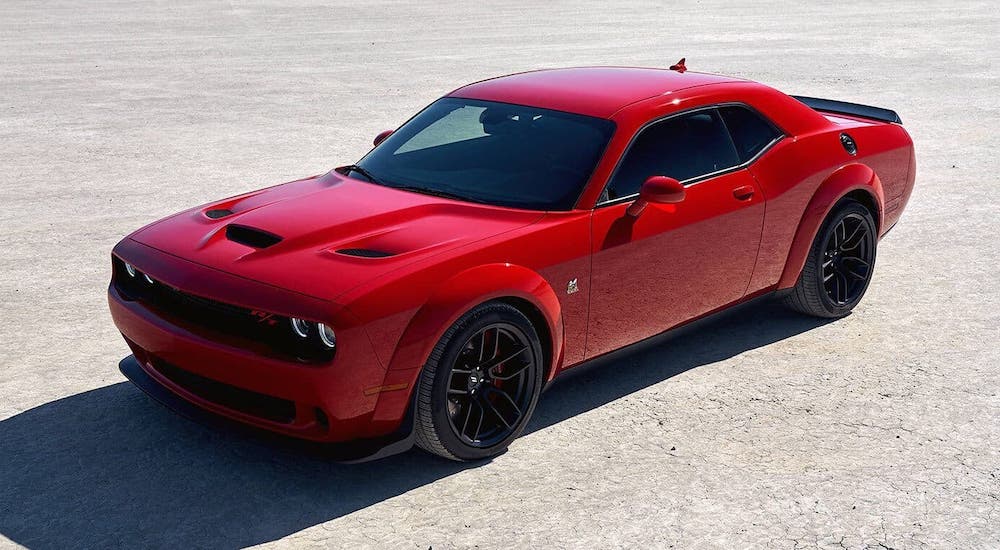 A popular used car near you, a red 2019 Dodge Challenger, is parked in an empty lot.