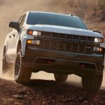 A white 2021 Chevy Silverado is off-roading on dirt.