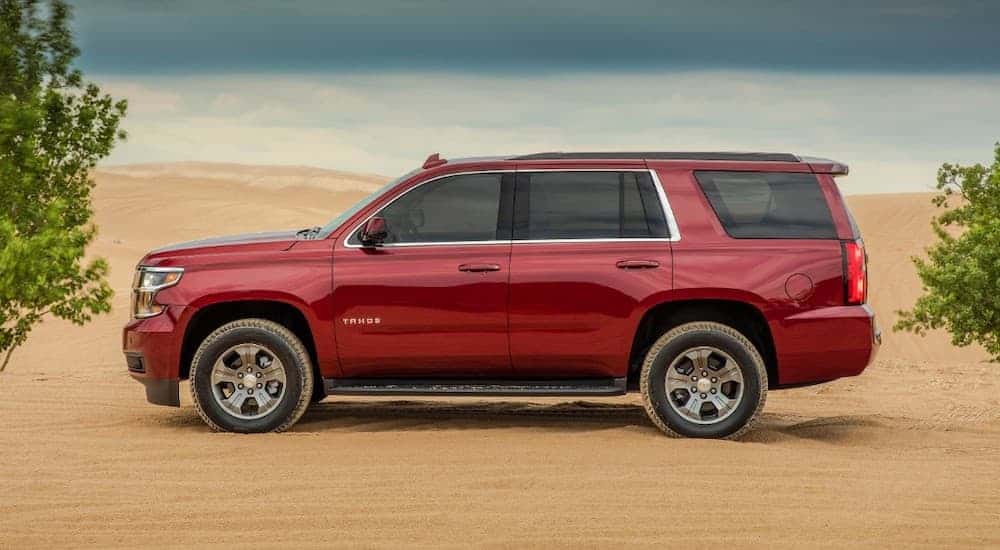 A red 2018 used Chevy Tahoe LS Custom is shown from the side in a desert.